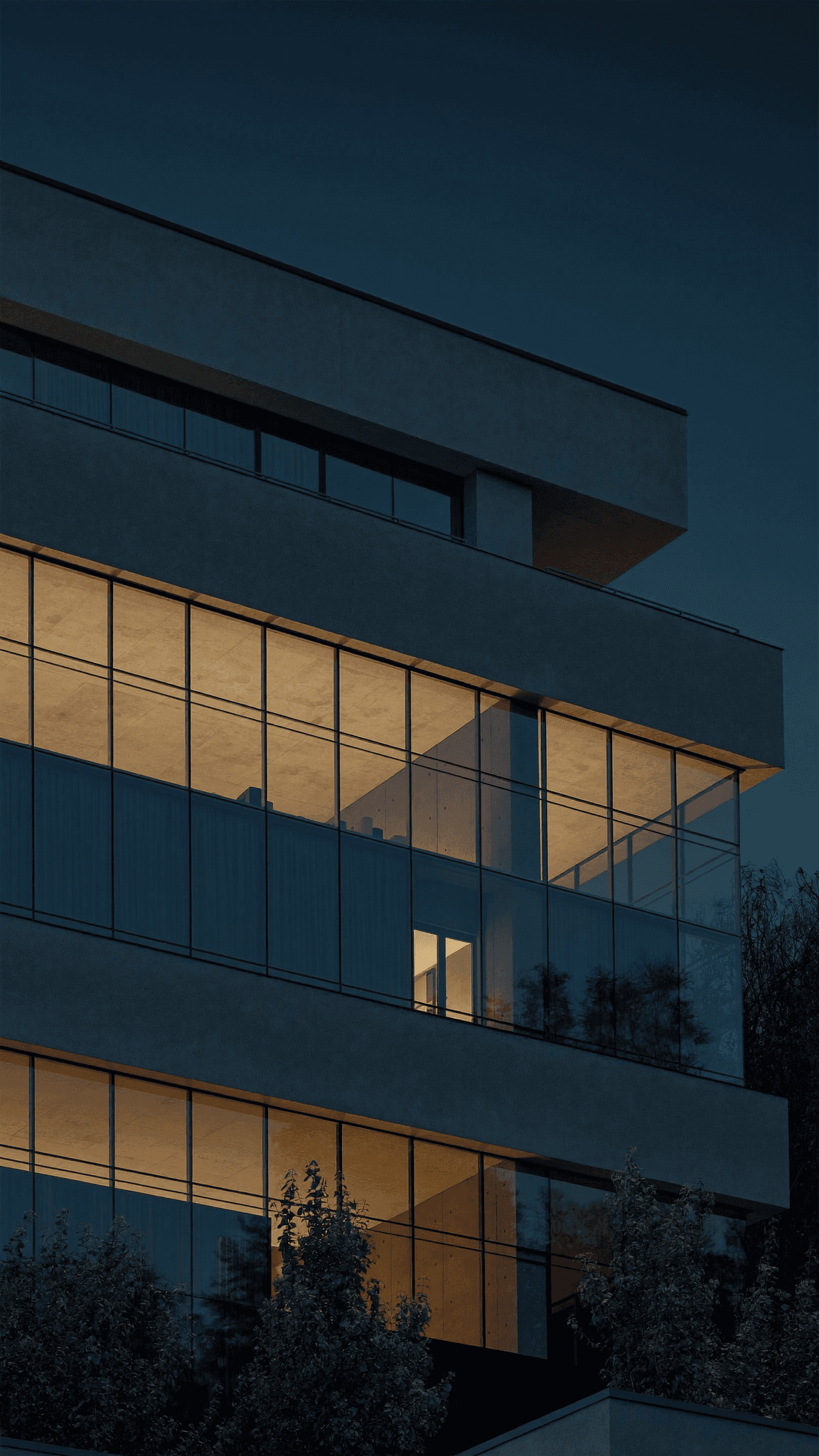 Modern campus building glowing at dusk